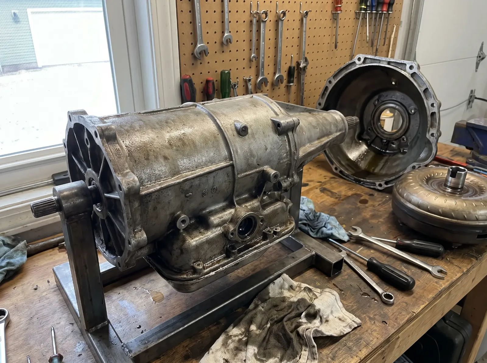 Vintage two-speed automatic transmission case on a workshop stand with bell housing and torque converter