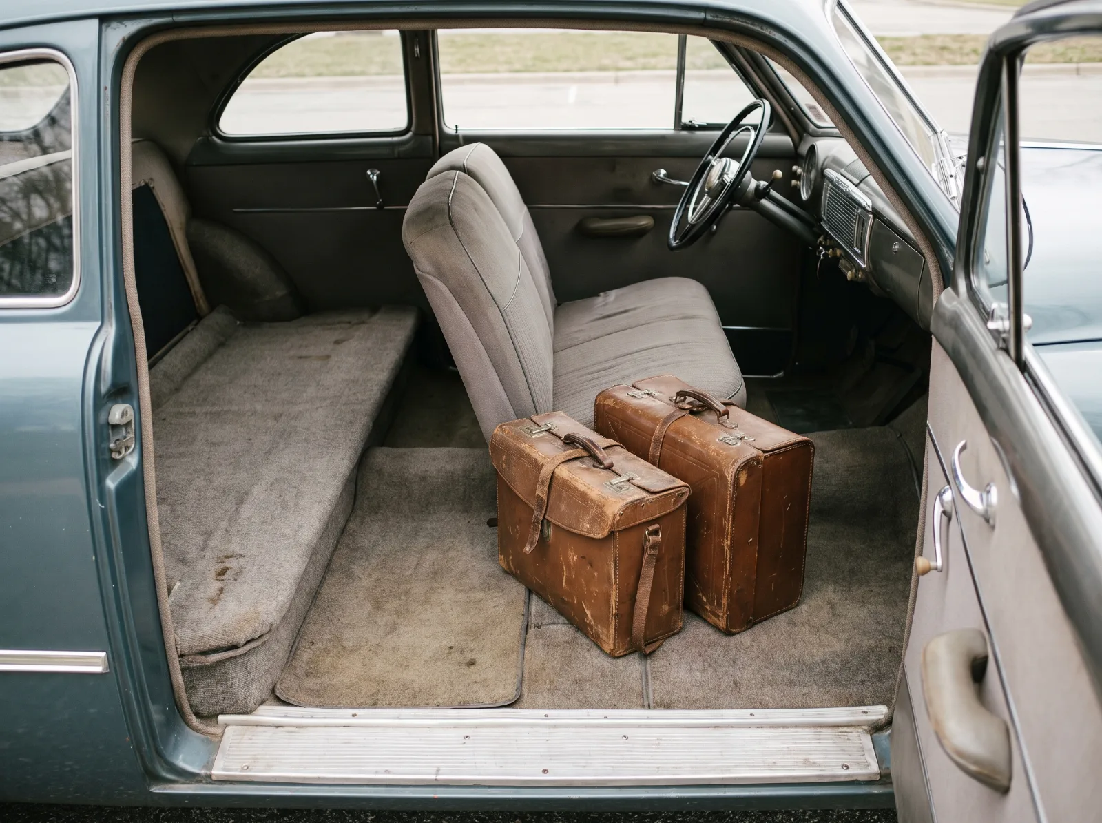 Business coupe interior showing the flat load floor where the rear seat would be, with sample cases on it