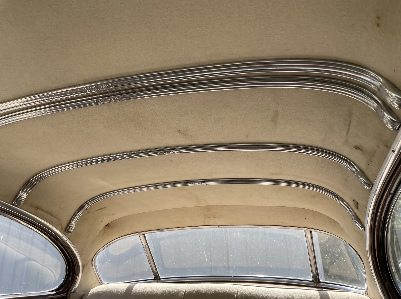 Chrome bows across the headliner of a 1951 hardtop, set in the pattern a folding convertible top's bows would take