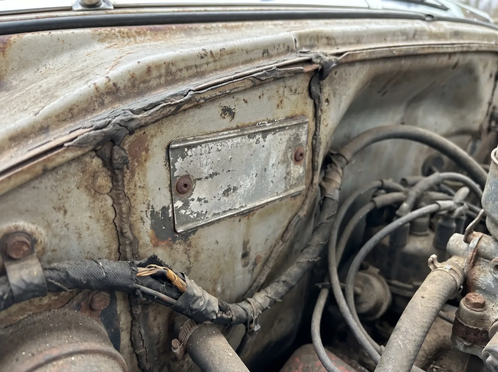 Fisher body identification plate riveted to the cowl under the hood of an early 1950s Chevrolet