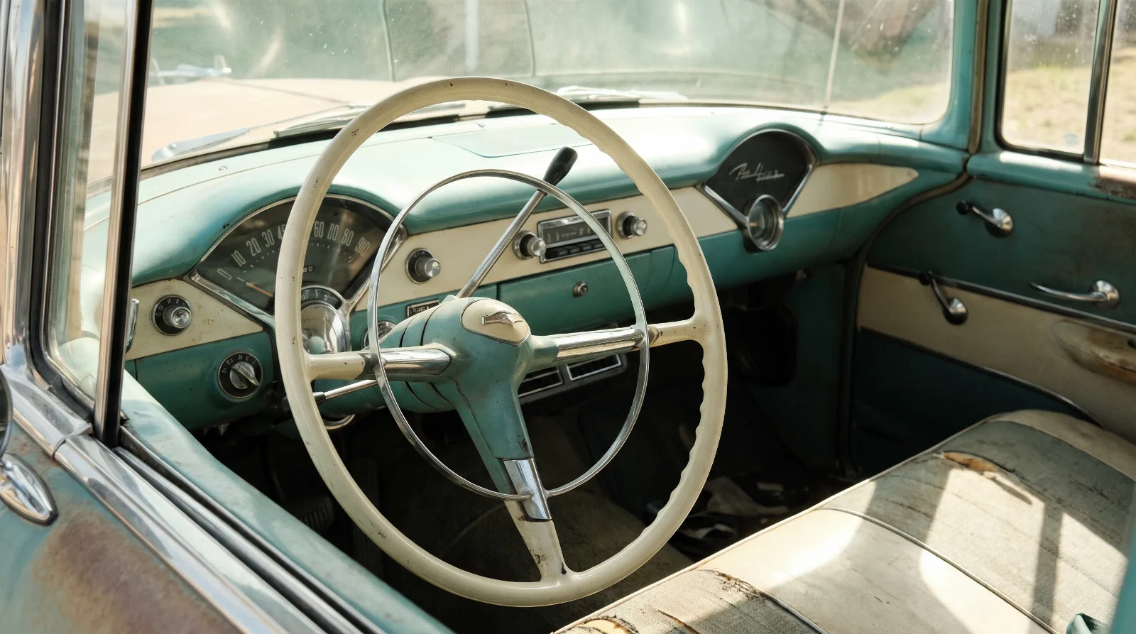 Column shift lever and steering wheel of an early 1950s Chevrolet seen from the driver's seat